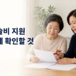 무릎 수술 전 지원 신청 서류를 함께 살펴보는 어머니와 성인 자녀